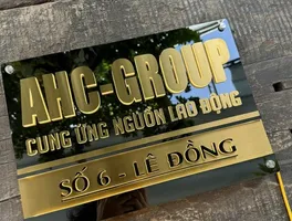 Bảng hiệu công ty AHC Group inox vàng xước nền đen chữ nổi 3D đèn LED halo backlit