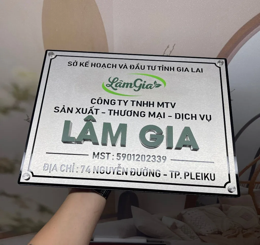 Chi tiết logo và chữ nổi 3D trên bảng hiệu công ty inox bạc xước – Bảng Hiệu Vàng Chi tiết logo LâmGia và chữ nổi 3D màu xanh lá trên nền inox bạc xước – bảng hiệu công ty chữ nổi màu tùy chỉnh