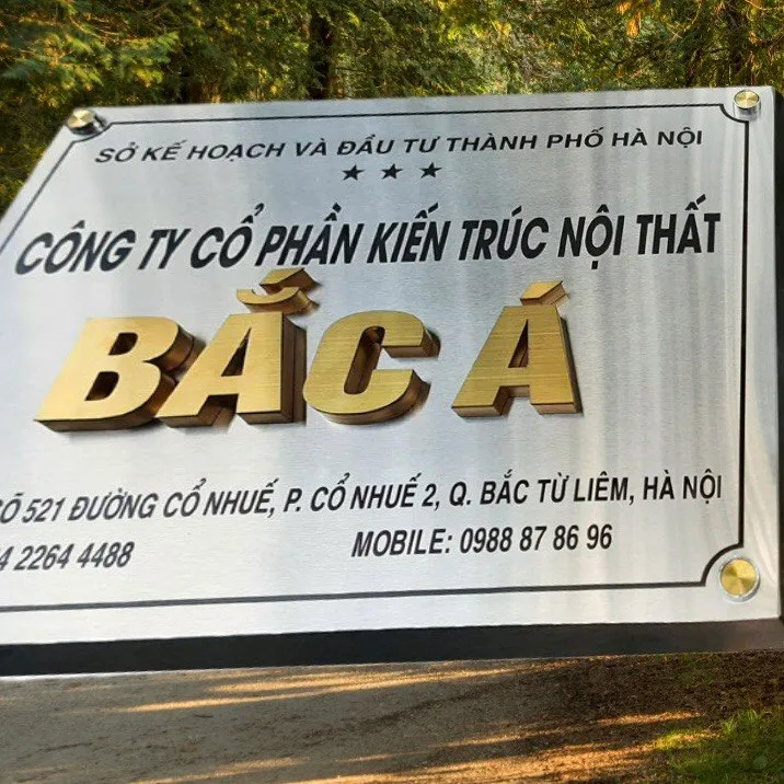 bảng hiệu công ty inox bạc xước chữ nổi vàng xước 3D nhìn góc nghiêng thấy bóng đổ tự nhiên dưới ánh sáng