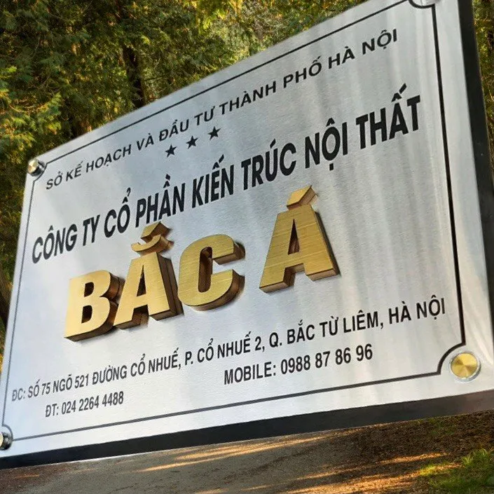 cận cảnh chữ nổi inox vàng xước brushed gold tương phản gold on silver trên bảng hiệu công ty inox trắng xước bạc