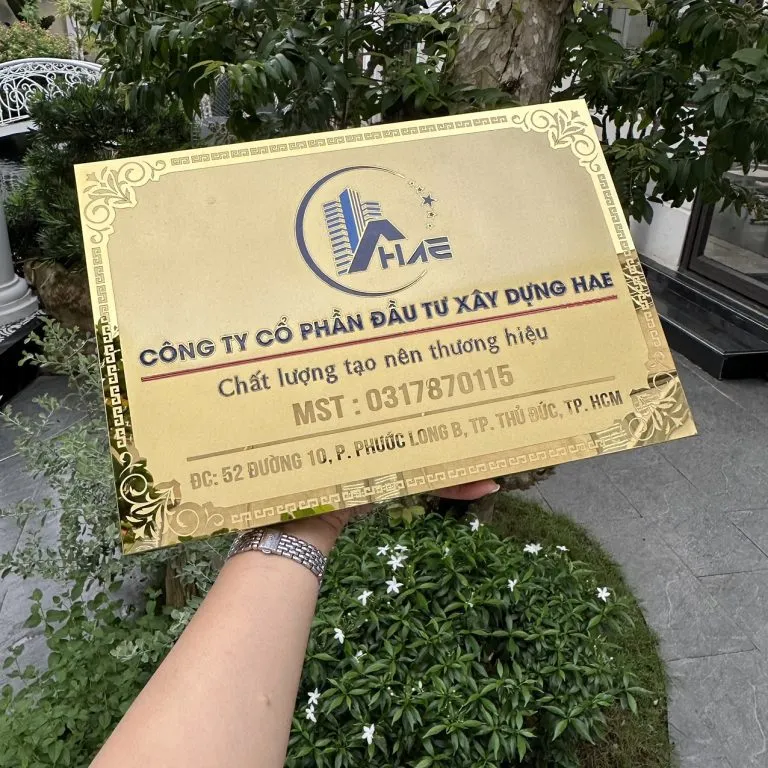 Bảng hiệu inox vàng gương – cận cảnh logo màu và chữ khắc CNC sắc nét cận cảnh logo màu thương hiệu và chữ khắc CNC sơn tĩnh điện sắc nét trên bảng hiệu công ty inox vàng gương