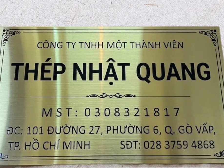 bảng tên công ty inox vàng xước ăn mòn kim loại gắn tường thực tế 