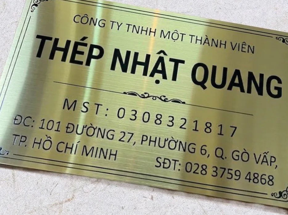 bảng hiệu công ty inox vàng xước ăn mòn sơn tĩnh điện đen ánh sáng tự nhiên