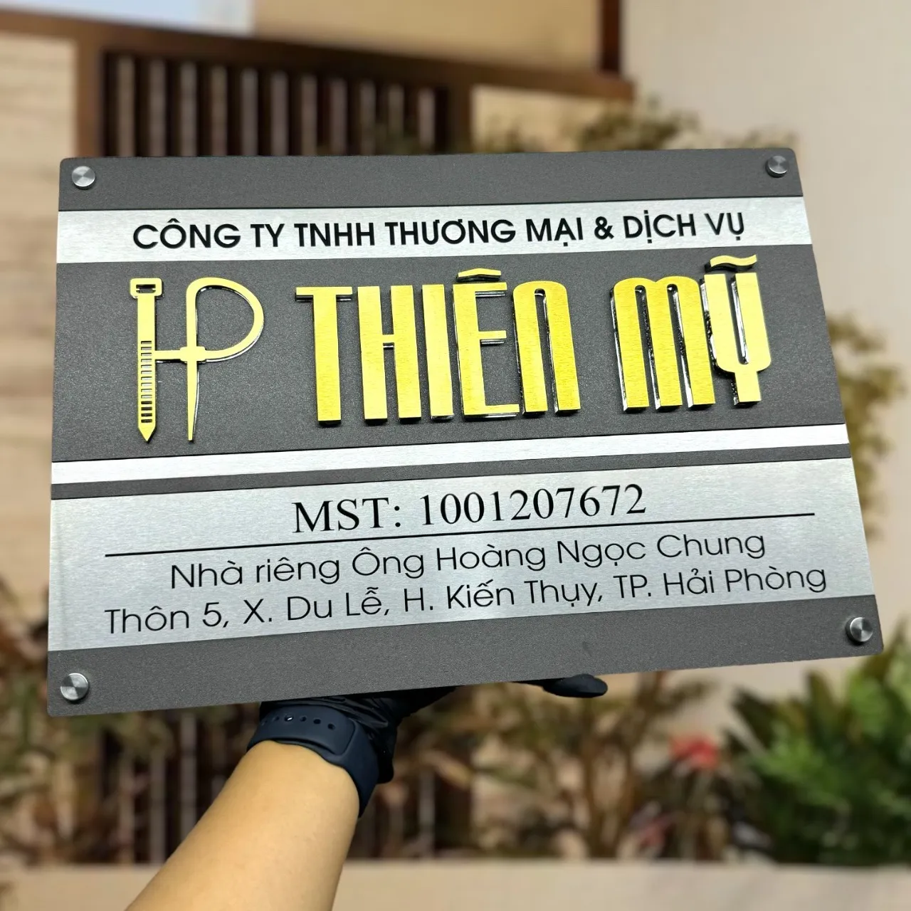 Bảng hiệu công ty TNHH thương mại dịch vụ inox xám khói chữ nổi 3D vàng có logo và mã số thuế