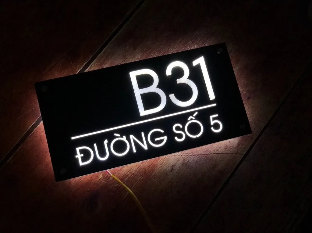 Bảng số nhà LED phát sáng ban đêm nhìn từ góc nghiêng – thấy rõ hào quang ánh sáng thoát ra mép bảng