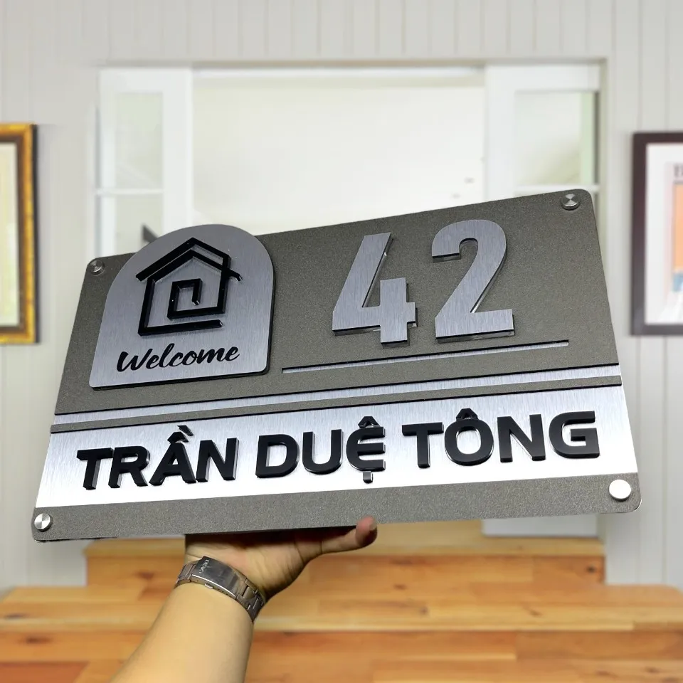 Hình ảnh cầm tay bảng số nhà inox 304 xước bạc giúp hình dung kích thước thực tế sản phẩm