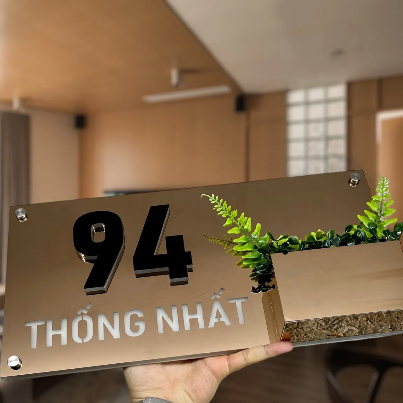 Bảng số nhà inox vàng gương tích hợp chậu cây góc cao nhìn xuống thấy đất trồng cây trong chậu