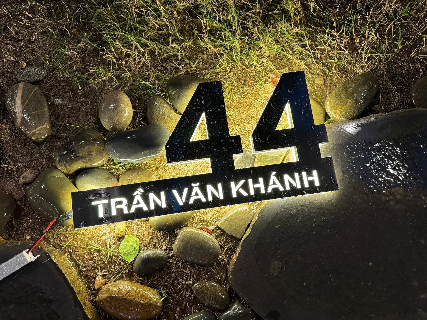 Bảng số nhà inox đen 3D LED halo trắng ngoài trời đêm trên nền đá sỏi