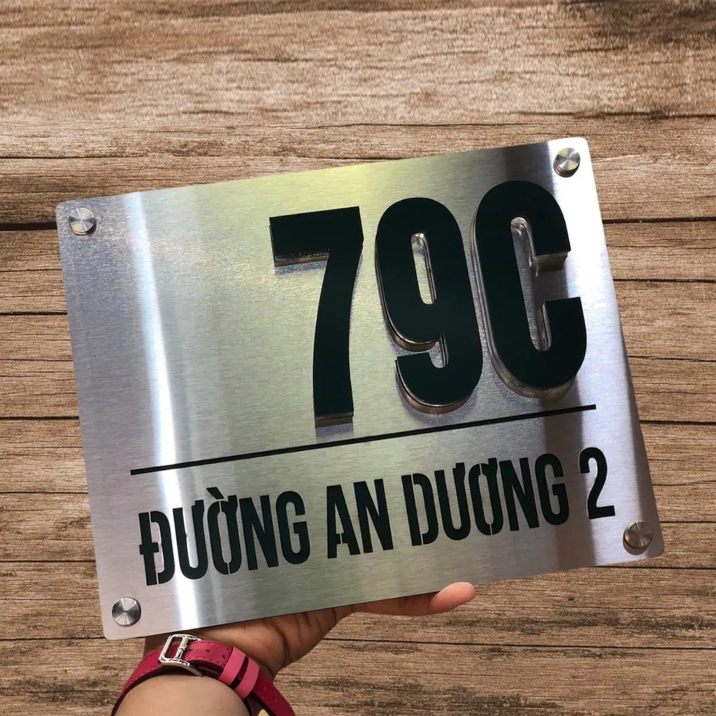 Bảng số nhà inox đơn giản chữ nổi đen trên nền xước bạc chụp dưới ánh sáng tự nhiên – bền đẹp không lỗi thời