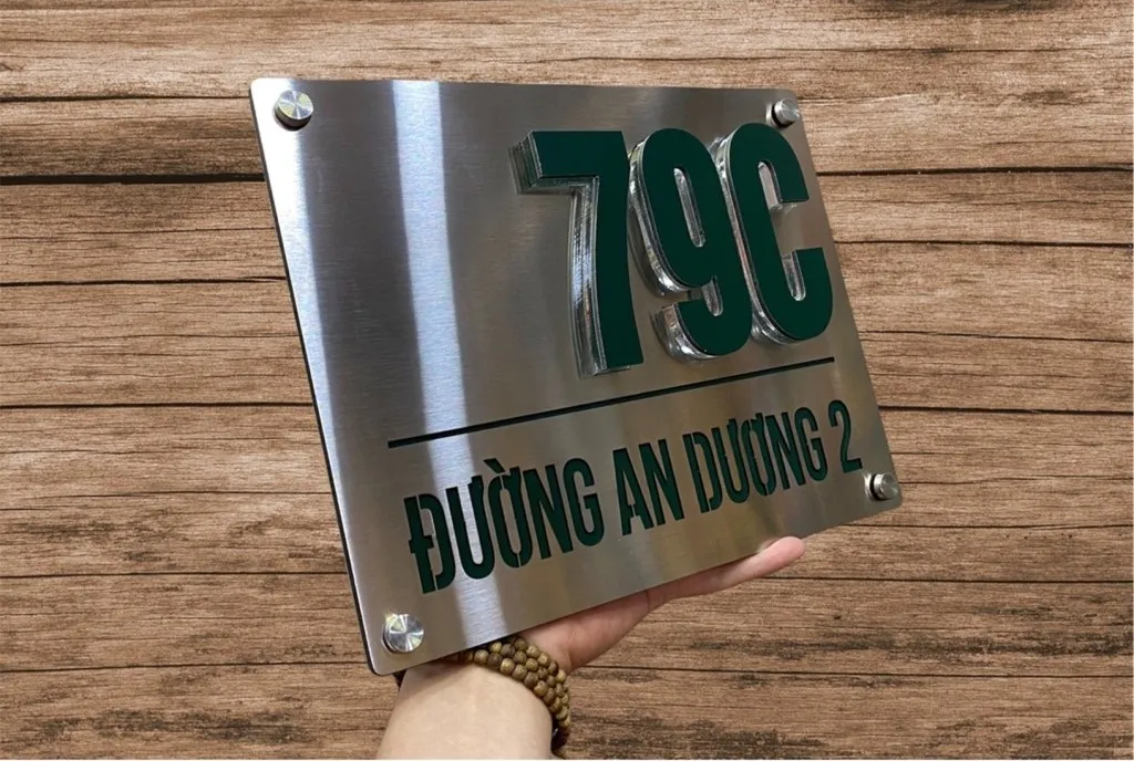 Bảng số nhà inox xước bạc chữ nổi sơn xanh lá chụp góc rộng thể hiện kích thước thực tế và chất lượng hoàn thiện toàn bộ sản phẩm