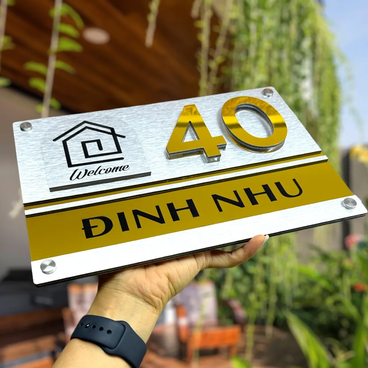 Bảng số nhà inox 304 vàng gương hoàn thiện thực tế, cầm tay thể hiện kích thước và chất lượng gia công