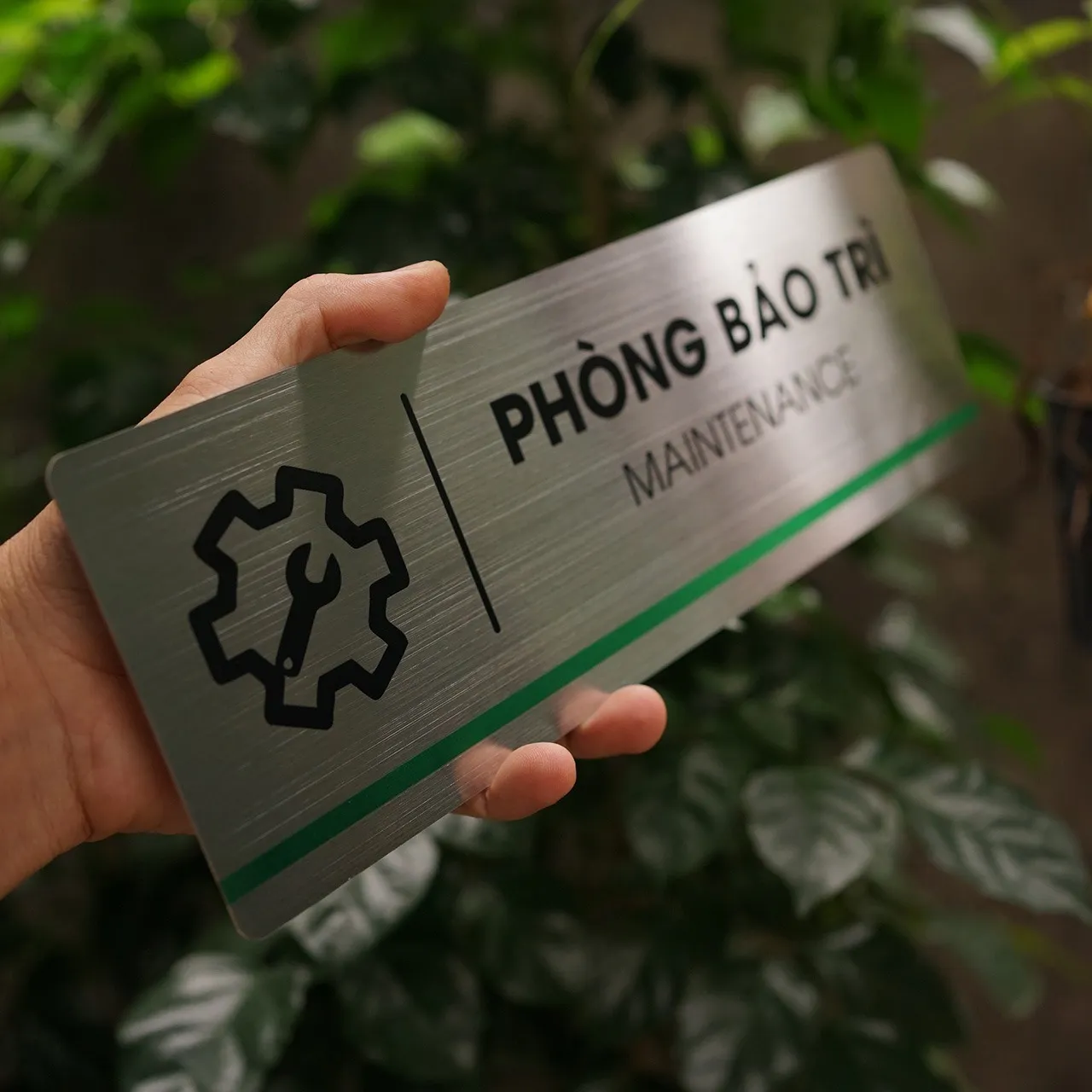 Cận cảnh độ dày và bề mặt xước phản quang của mẫu bảng phòng bảo trì khi cầm trên tay.