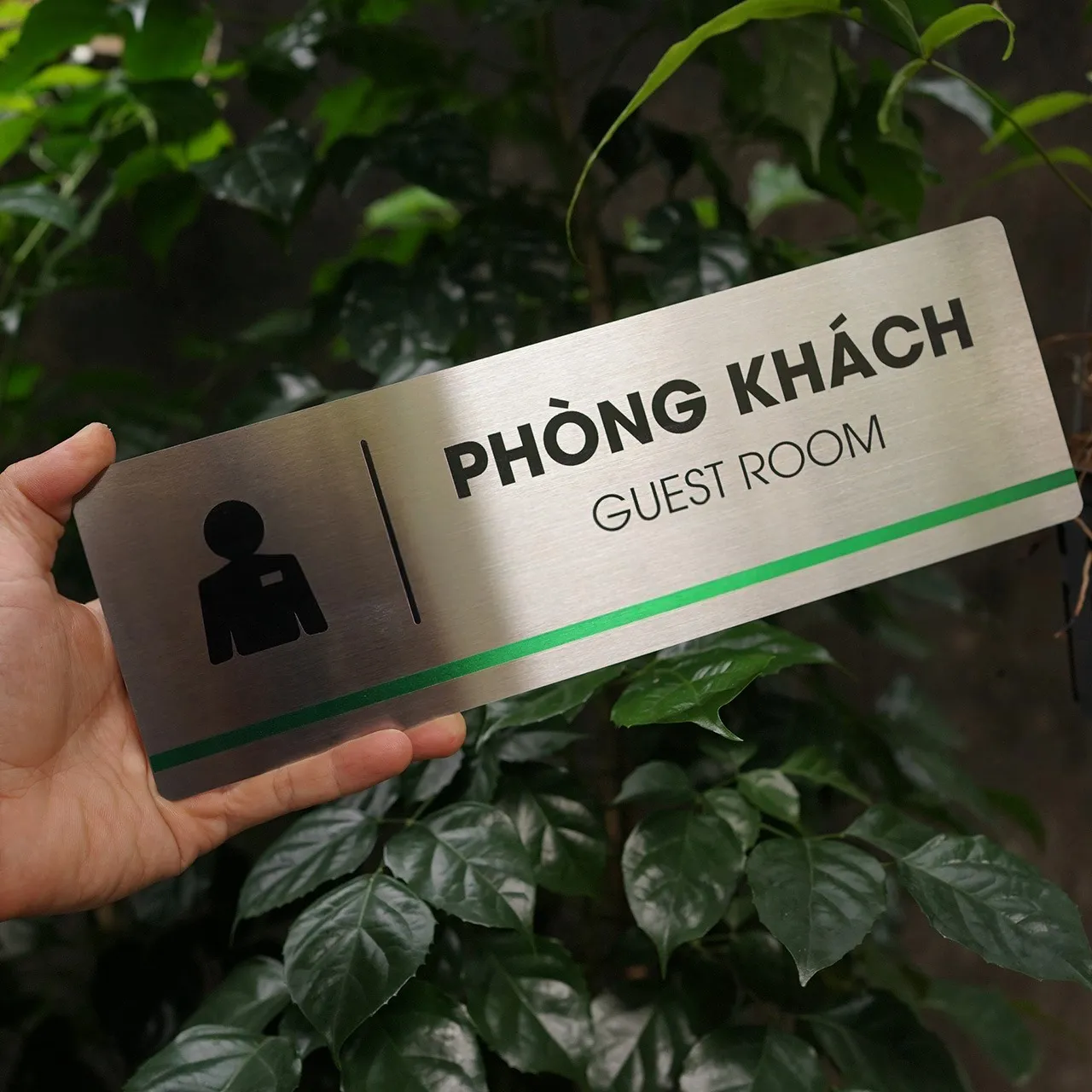 Bảng tên phòng khách inox 304 góc nghiêng phải – thấy rõ viền bo và bề mặt phay xước Bảng tên phòng khách inox 304 cầm tay nghiêng phải thấy rõ viền bo cạnh và sọc xanh lá
