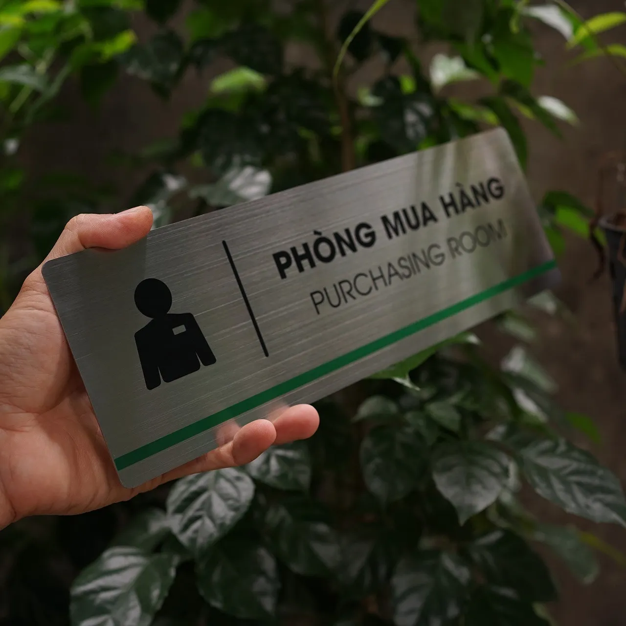 Bảng tên phòng mua hàng inox 304 cầm tay góc nghiêng phải thấy rõ chữ in UV đen sắc nét