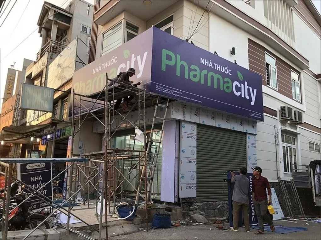 Thi công lắp đặt bảng hiệu Pharmacity - Công nhân đang gắn biển