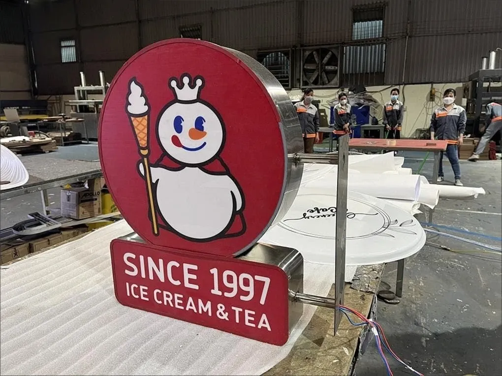 Hộp Đèn Mixue Đang Hoàn Thiện Cuối Cùng Tại Xưởng Công nhân đang hoàn thiện hộp đèn Mixue với logo người tuyết tại xưởng sản xuất