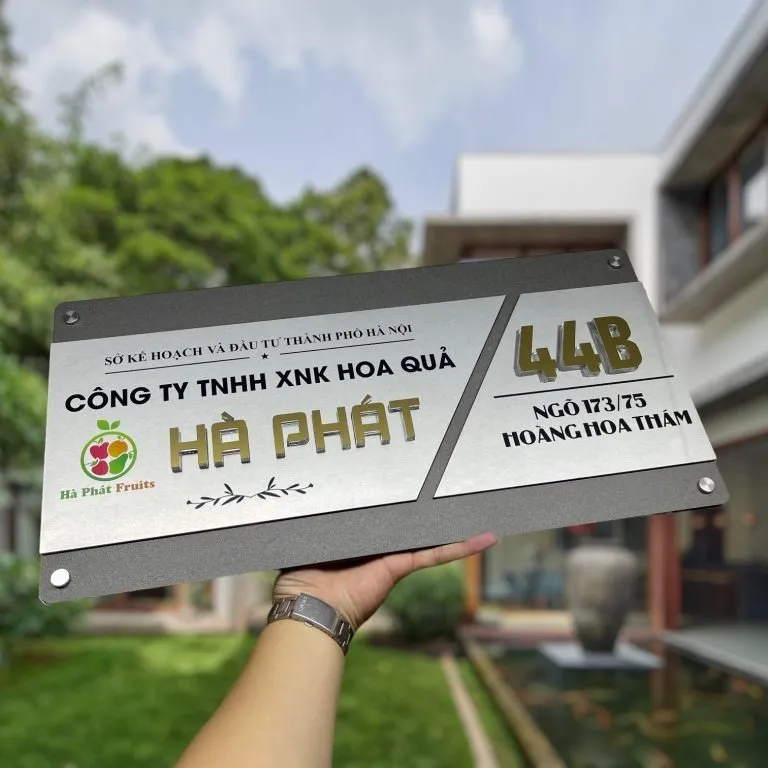 Bảng hiệu công ty inox 2 lớp xám khói chữ nổi 3D vàng xước chụp phối cảnh thực tế ngoài trời