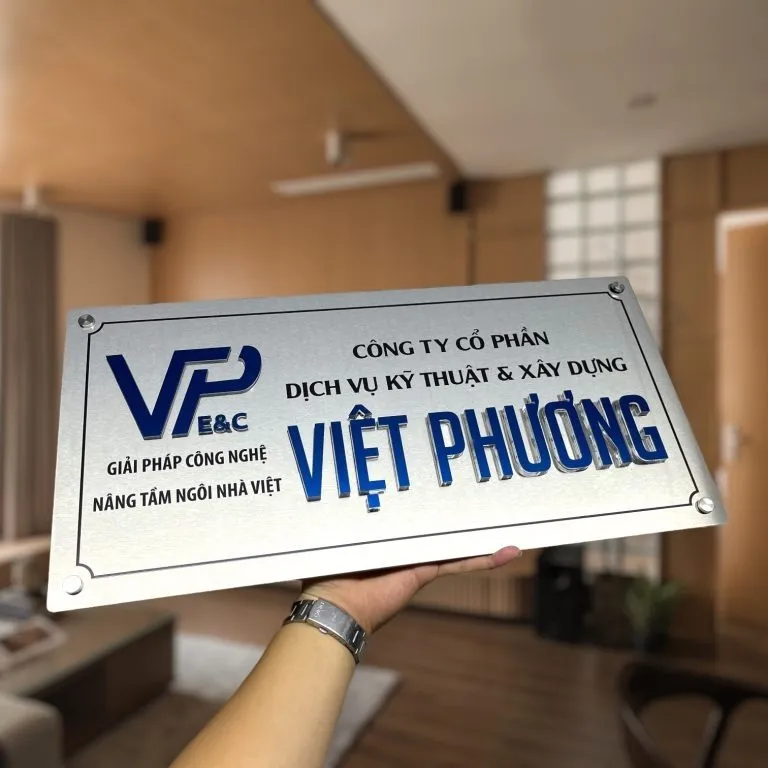 cận cảnh logo và chữ nổi inox sơn tĩnh điện xanh dương sắc nét trên bảng hiệu công ty inox trắng xước bạc