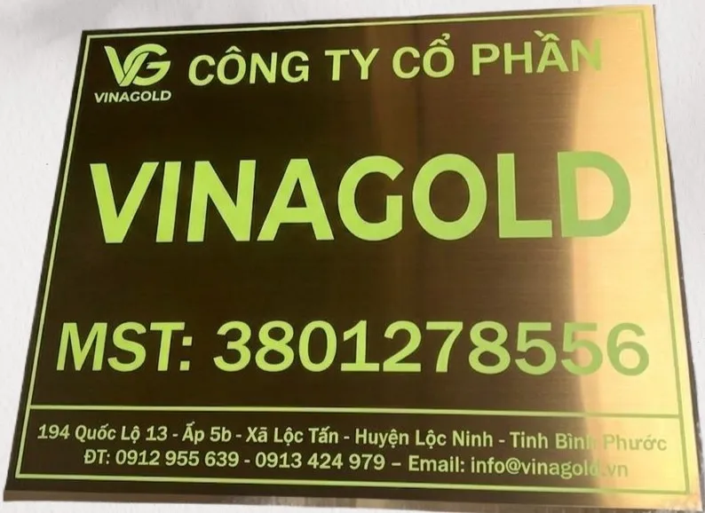 cận cảnh chữ in UV màu xanh lá sắc nét trên nền inox vàng đồng xước