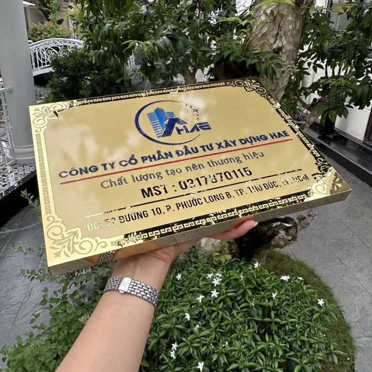 Bảng hiệu inox vàng gương khắc CNC – hiệu ứng phản chiếu góc nghiêng bảng hiệu công ty inox vàng gương khắc CNC phản chiếu ánh sáng rực rỡ nhìn góc nghiêng