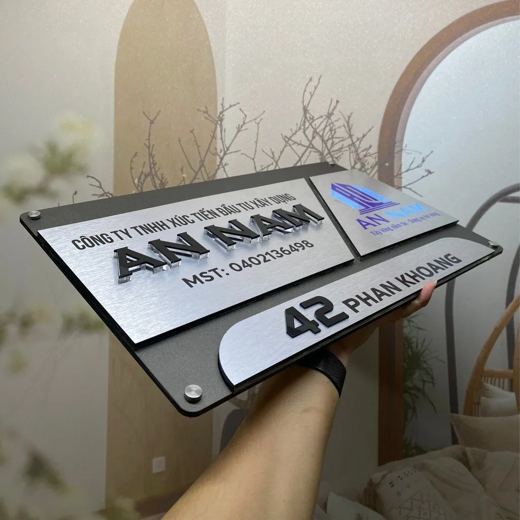 Bảng hiệu công ty inox xám khói bạc 3 mảnh chữ nổi 3D đen logo màu nhìn góc nghiêng phải thấy rõ chiều sâu lớp