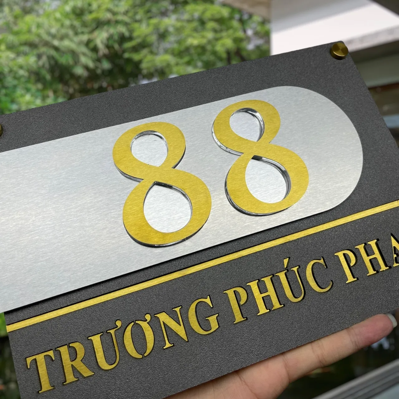 Chi tiết chữ số inox vàng gương 24K nổi 3D trên tấm inox xước bạc viền cong – Bảng Hiệu Vàng