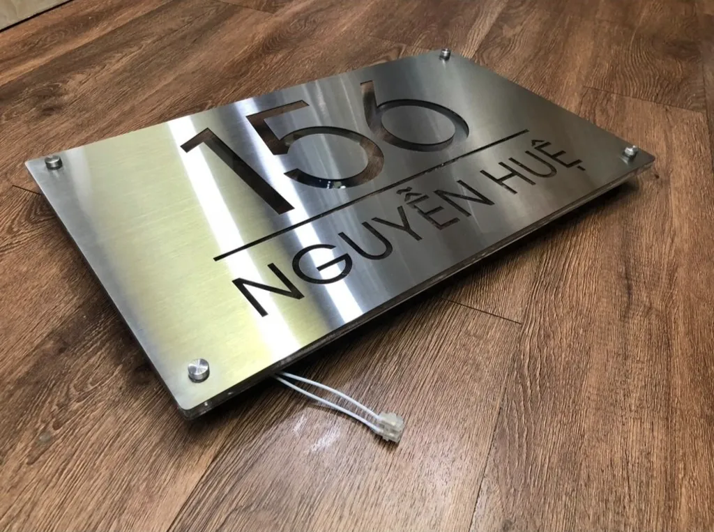 Bảng số nhà inox 304 hairline chụp góc nghiêng 45 độ, thấy rõ cạnh vuông và vân chải bề mặt