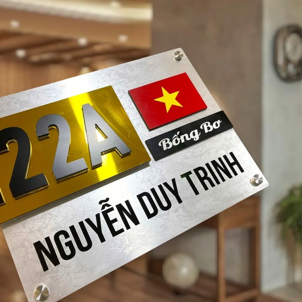 Cận cảnh họa tiết cờ đỏ sao vàng và tên riêng trên bảng số nhà inox Chi tiết cờ đỏ sao vàng 3D và dải tên riêng cá nhân hóa trên bảng số nhà Bảng Hiệu Vàng