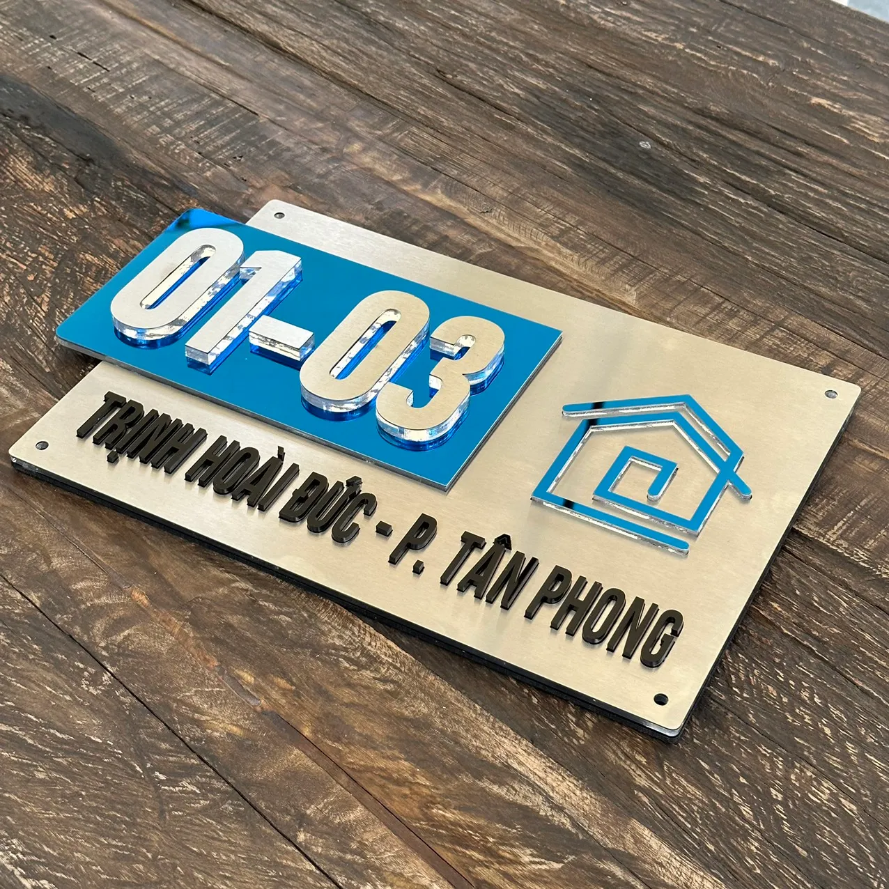 Bảng số nhà inox 3D xanh gương nhìn toàn cảnh trên nền gỗ mộc – Bảng Hiệu Vàng