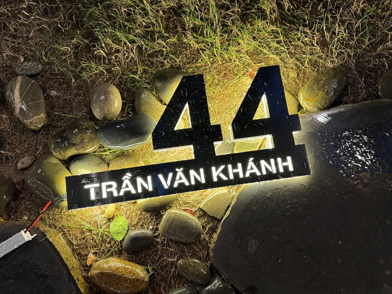 Bảng số nhà inox đen 3D LED halo trắng ngoài trời đêm trên nền đá sỏi