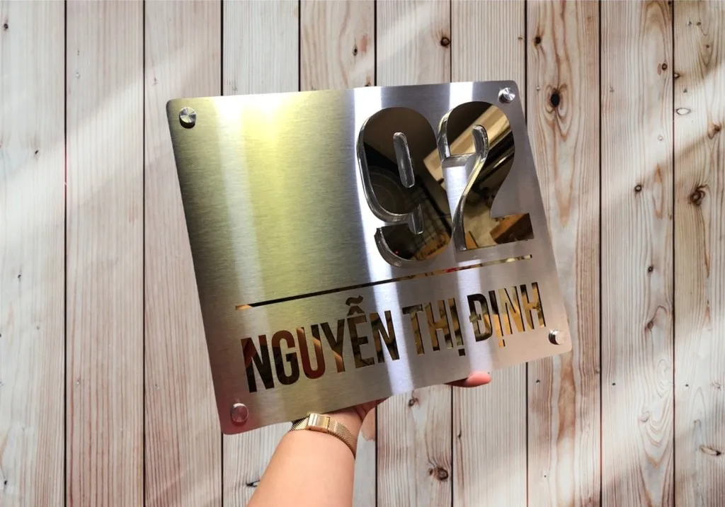 Bảng số nhà inox xước bạc vàng gương tối giản siêu mỏng 5mm đặt trên nền gỗ tự nhiên – tương phản chất liệu sang trọng