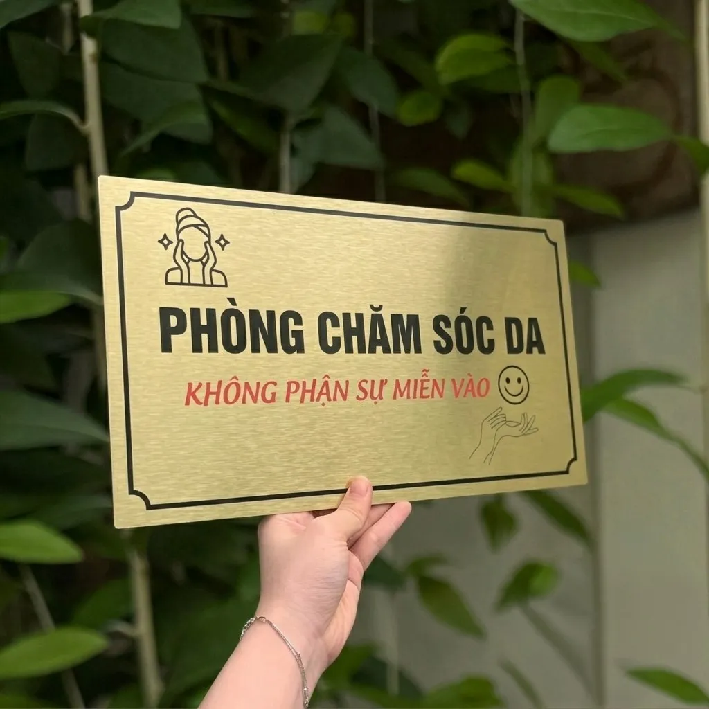 Cận cảnh chữ khắc ăn mòn trên bảng tên phòng chăm sóc da Cận cảnh đường nét chữ ăn mòn hóa học trên inox vàng xước