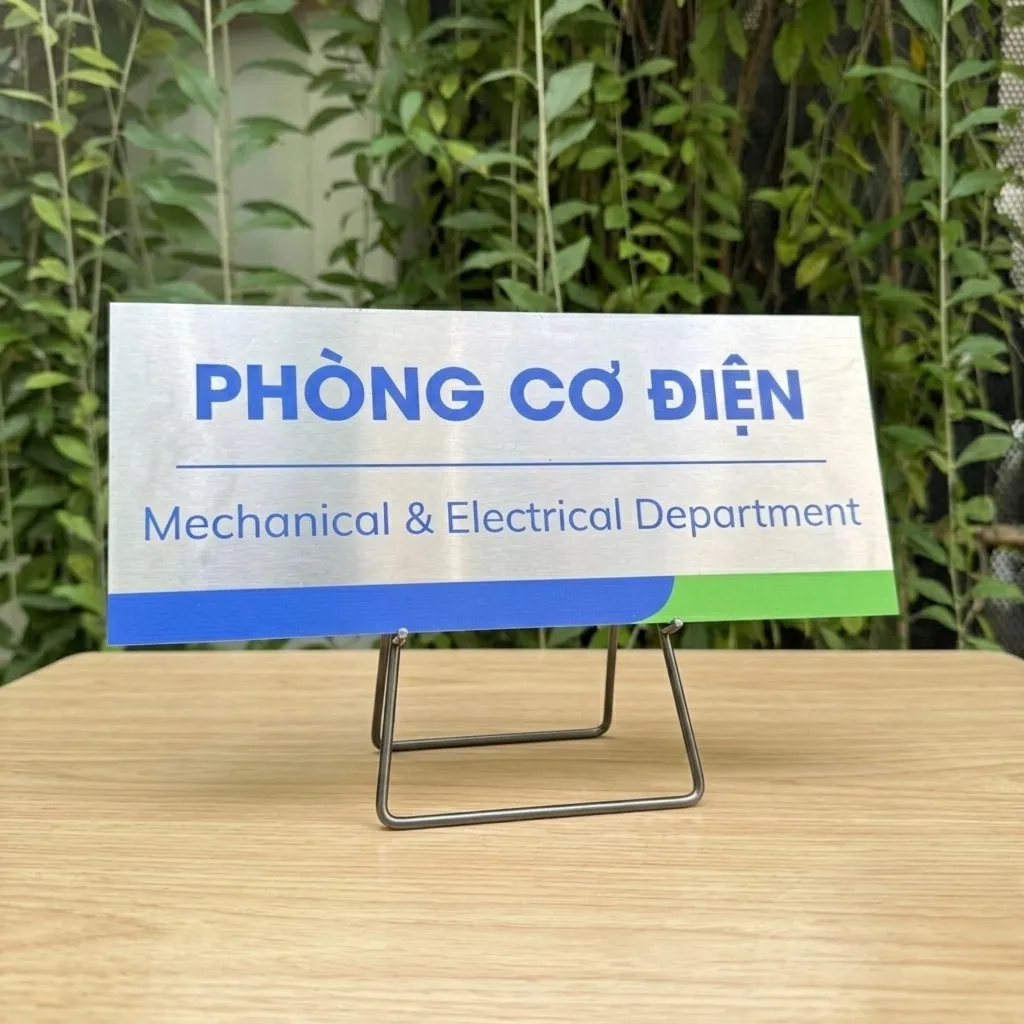 Bảng tên phòng cơ điện inox đặt trên giá đỡ ngoài trời – Bảng Hiệu Vàng Bảng tên phòng cơ điện inox 304 đặt trên giá đỡ inox, nền cây xanh ngoài trời