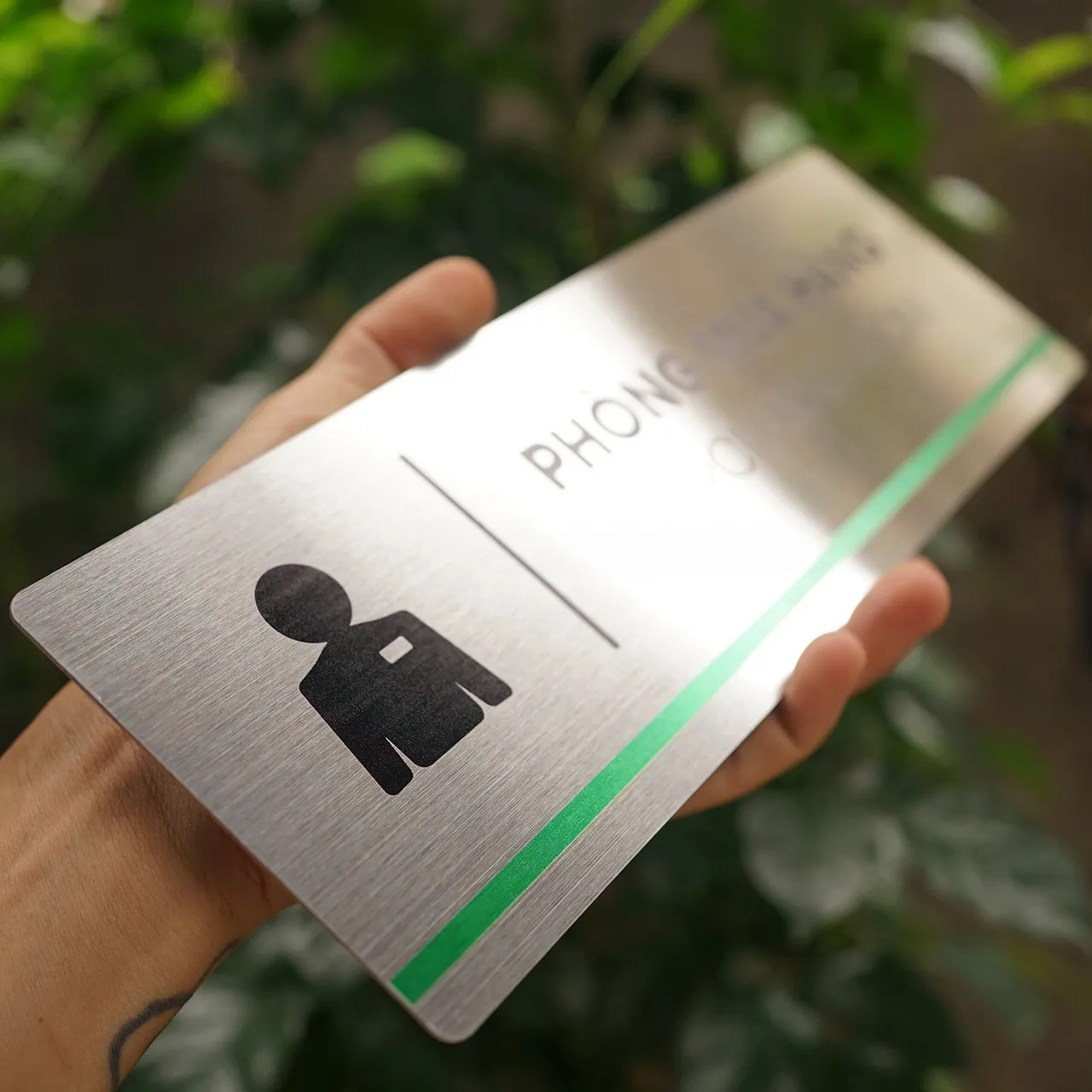 Cận cảnh pictogram nhân vật và sọc xanh lá bảng tên phòng mua hàng inox 304 phay xước