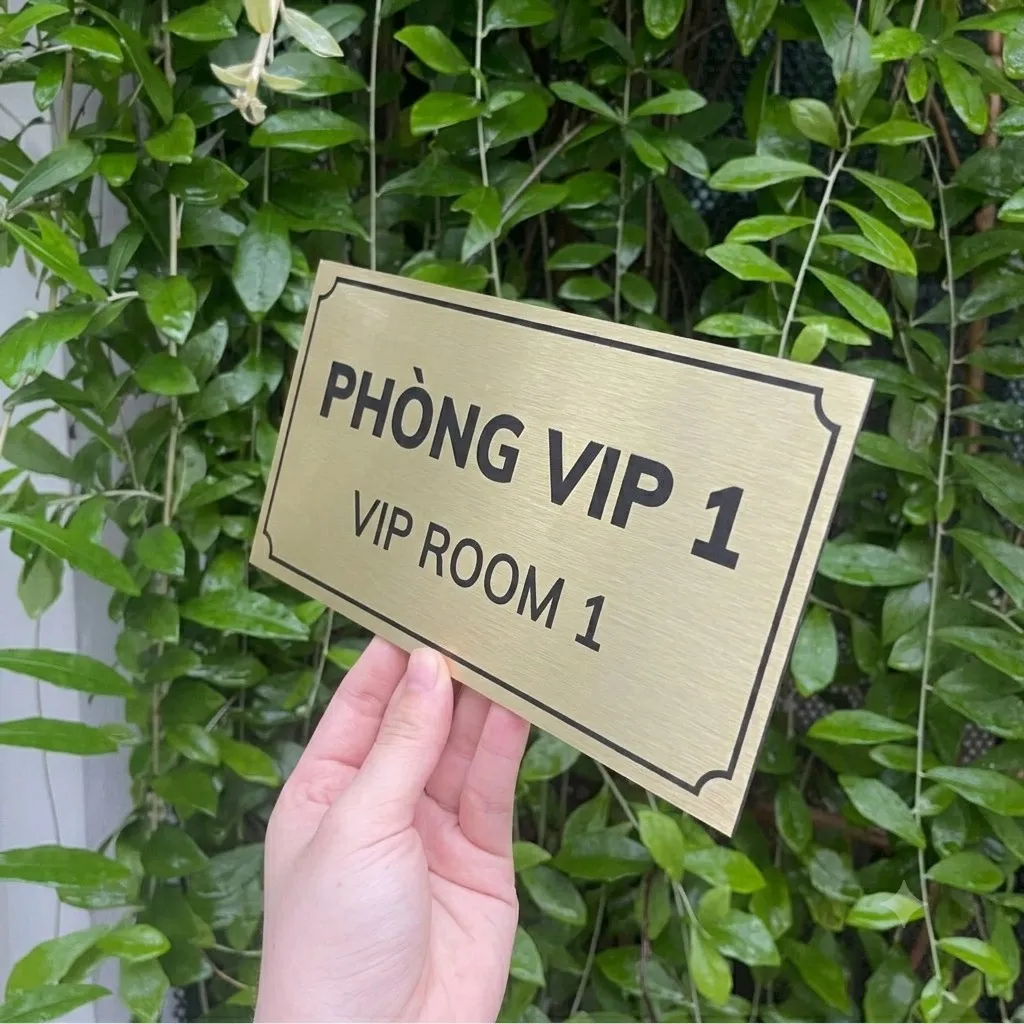 Cận cảnh chữ song ngữ trên bảng tên phòng VIP inox vàng xước Cận cảnh chữ PHÒNG VIP và VIP ROOM trên nền inox vàng xước